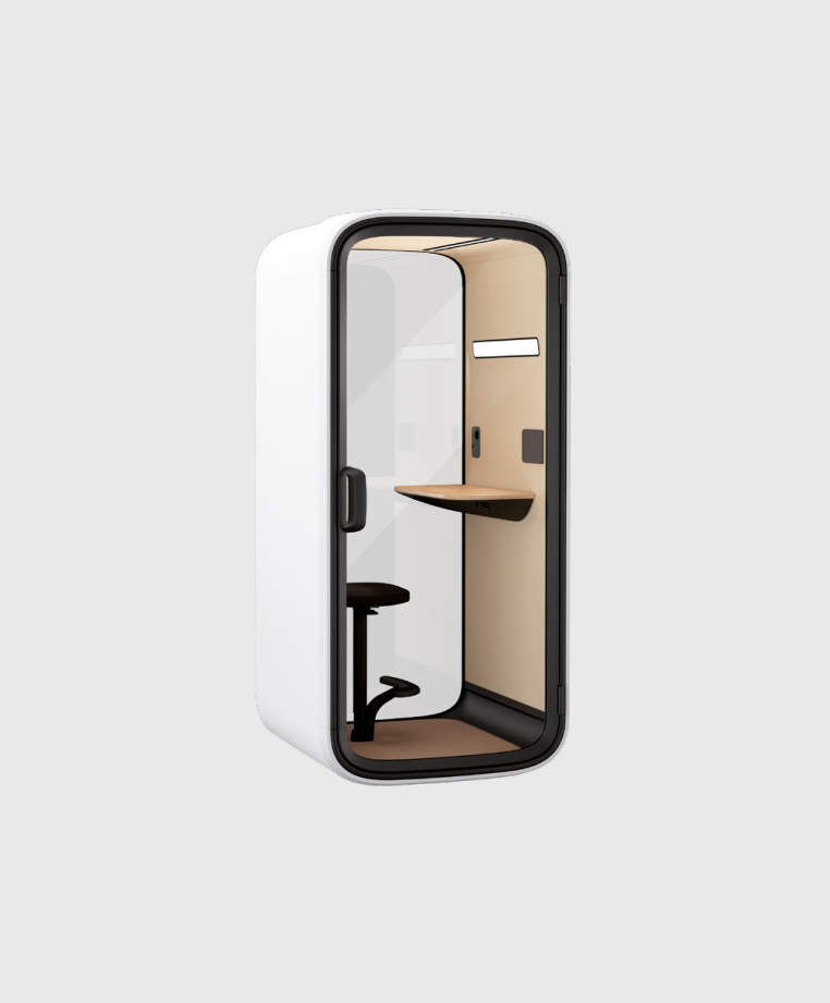 Eine kompakte, moderne Telefonzelle mit Glastür, kleinem Schreibtisch, Hocker und einer Innenausstattung aus hellem Holz, die für ungestörtes Arbeiten oder Telefonate konzipiert ist. Die Zelle hat eine minimalistische weiße Außenfassade.